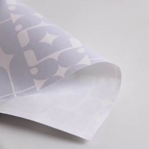 Wrapping paper featuring a white design with grey geometric patterns. The paper has a smooth, glossy finish.