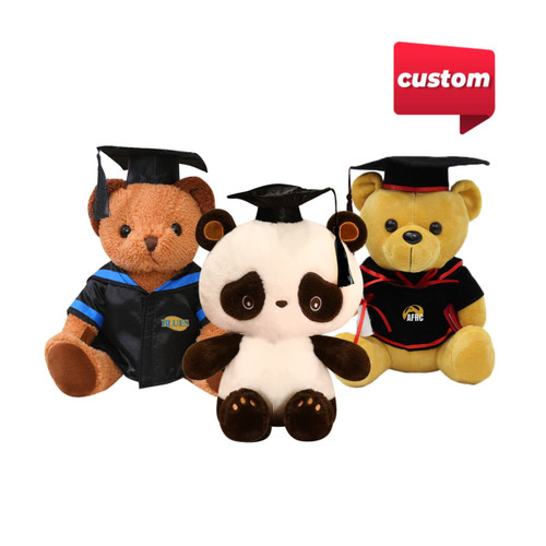 Three plush toys in graduation caps: a brown bear in a blue gown, a panda in white, and a yellow bear in a black gown.