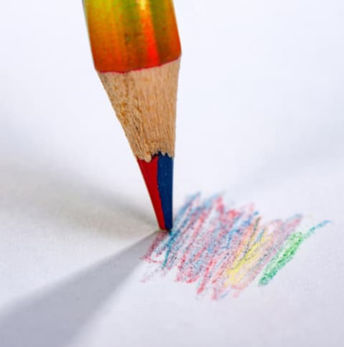 A long four-colour pencil with a red, blue, green, and yellow tip, marked on white paper. It has a logo on the body.