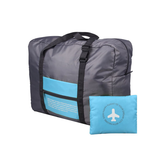 A grey travel compressed bag with a blue pocket and a matching blue pillow. The bag features handles and a logo.
