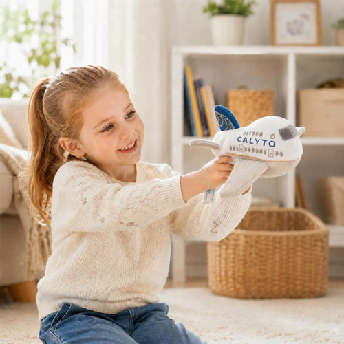 A child smiles while holding a plush airplane toy in white and blue, featuring a logo. The scene is bright and cheerful.