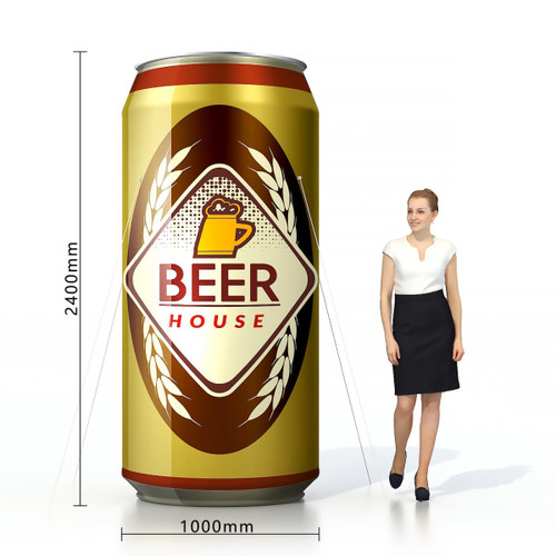 An inflatable can design in gold and brown, featuring a logo, beside a person for scale.
