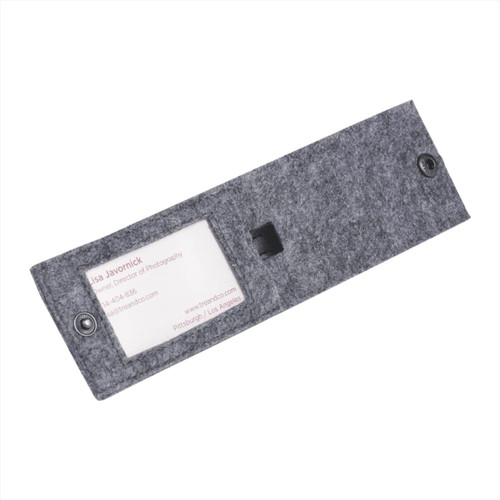 A grey recycled felt luggage tag with a transparent window for displaying information and a button closure.