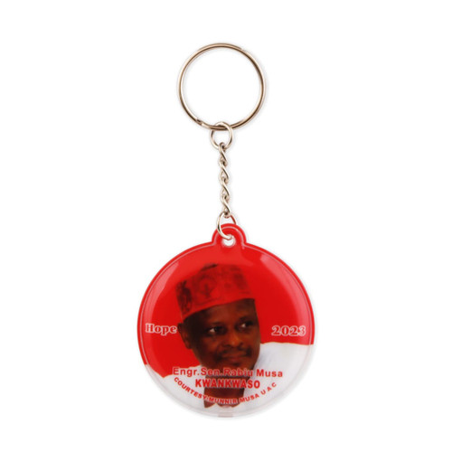 A red PVC LED keyring featuring a circular design and an image of a person, along with a branding logo.