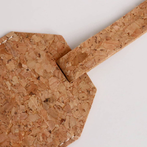 A cork luggage tag featuring an octagonal shape and a matching strap, showcasing natural cork texture.
