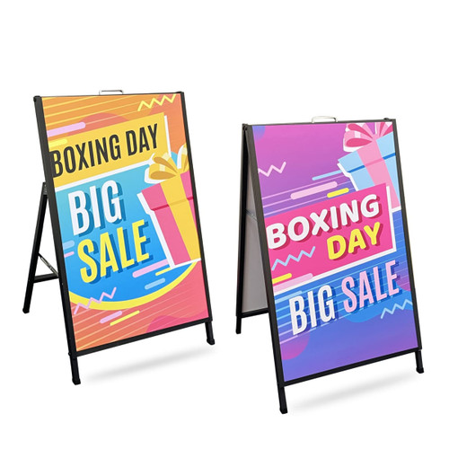 Two metal A-frame signs with vibrant designs featuring bright colours, advertising a Boxing Day sale. Each sign has a logo.