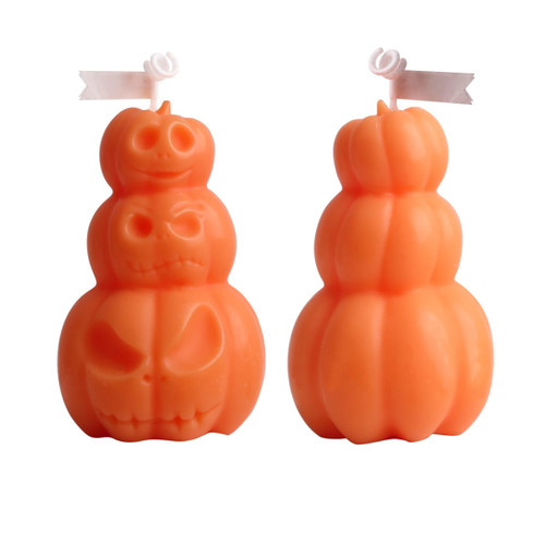 Triple pumpkin-shaped candles in vibrant orange with carved faces, featuring a playful design.