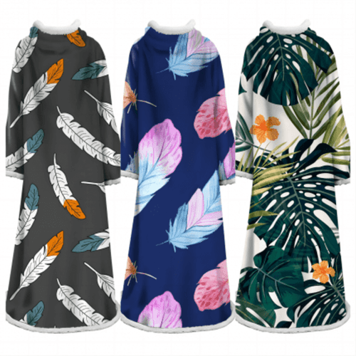 A blanket featuring three designs: feather patterns in grey, vibrant leaves on navy, and tropical leaves with flowers on white.