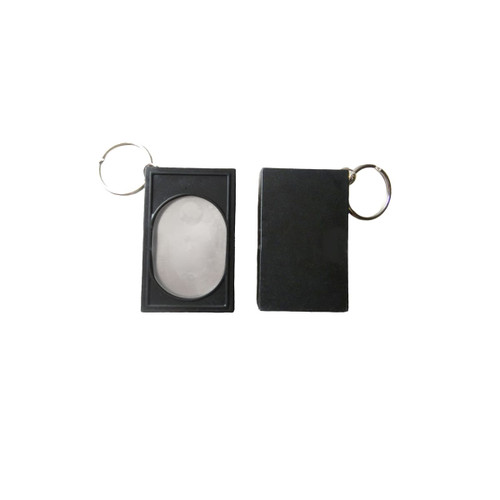 A black pet training clicker with a keychain attachment, featuring a smooth, oval button and a rectangular casing.
