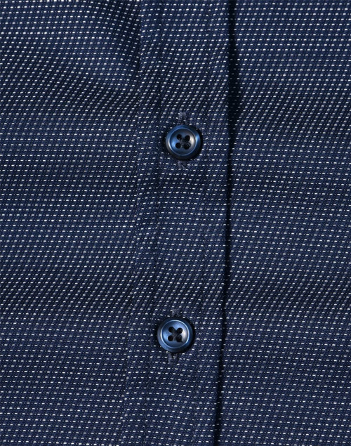 A navy blue button-up shirt with a pin dot pattern and blue buttons. Features a textured fabric design.