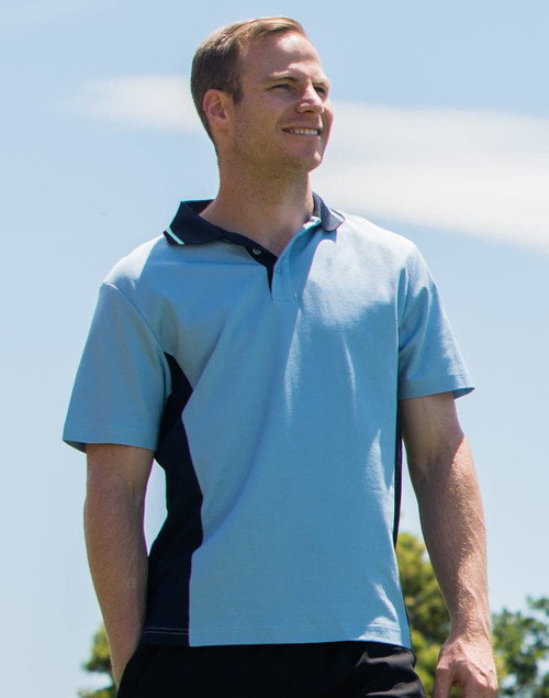A light blue polo shirt with black contrast panels and a logo on the chest, featured on a model outdoors.