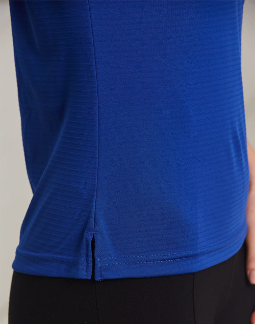A close-up of a textured polo shirt in vibrant blue, featuring a small slit detail at the hem and a logo.