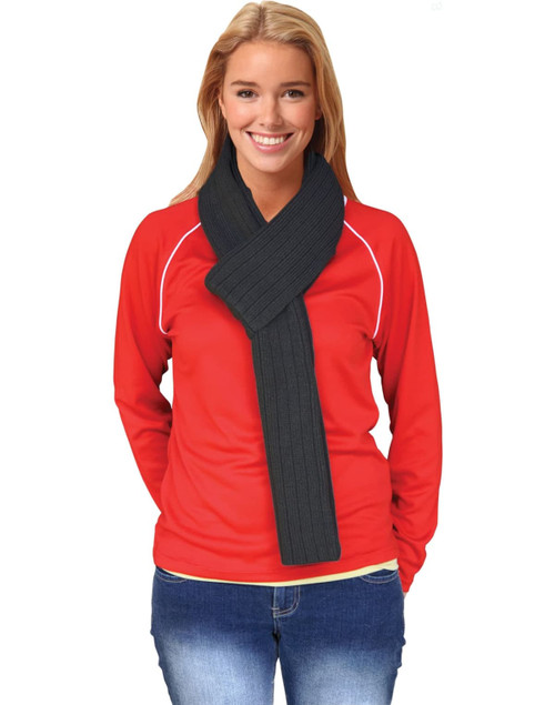 A woman wearing a dark grey cable knit scarf with a ribbed pattern, paired with a red top and jeans.