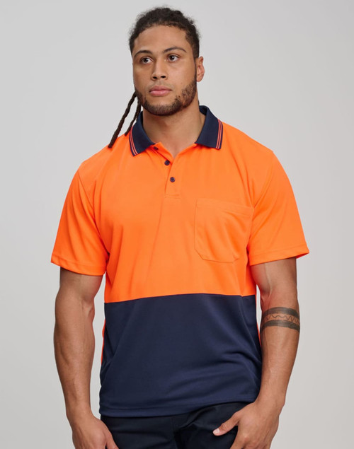 A man wears a high-visibility orange and navy short-sleeve safety polo shirt with a pocket. The shirt features a logo.