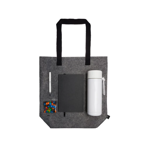 A gray tote bag containing a drink bottle, a notebook, a pen, and a small bag of candies.