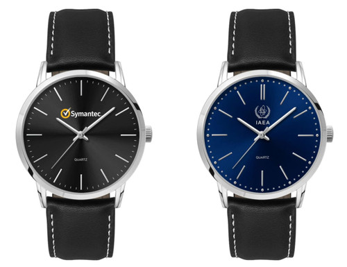 A men's dress watch with a black dial and silver hands, featuring a leather strap. Another watch has a blue dial.