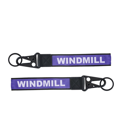 A purple Jacquard keyring featuring a black clip and two keyring loops. It has a branding element.