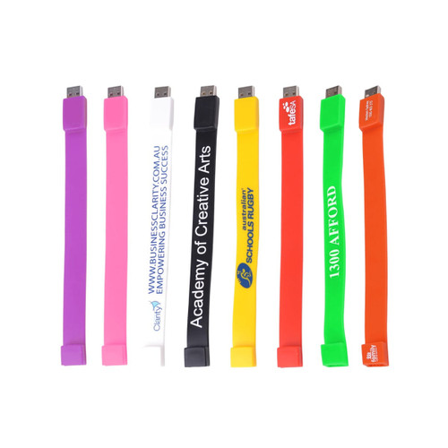A variety of rectangular silicone wristband flash drives in colours including pink, white, yellow, green, orange, and purple, each with logos.