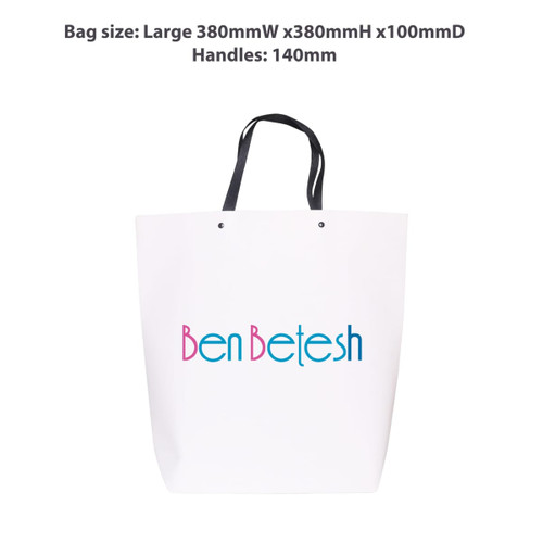A large white boutique paper bag with black handles and a logo printed in blue and pink.