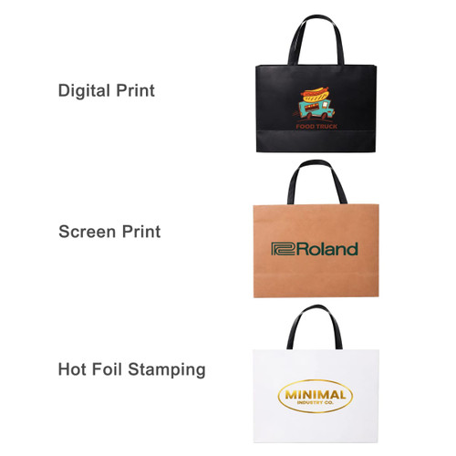 A black, brown, and white paper bag each featuring different prints and logos, with flat handles.