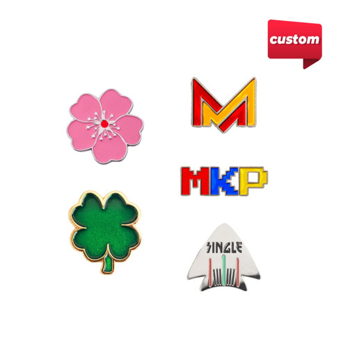 A collection of four custom soft enamel golf ball markers in pink, green, and a multicoloured design, each with a distinct shape and logo.