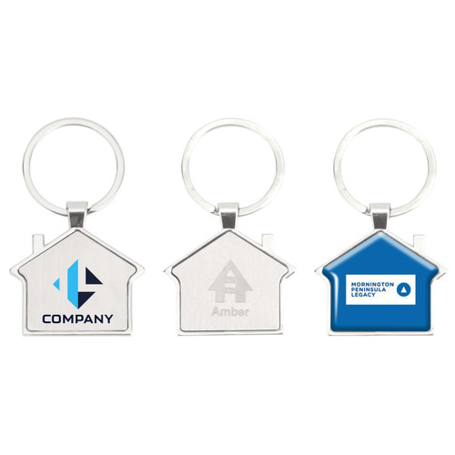 A collection of three metal house-shaped keyrings in silver and blue, featuring different branding designs.