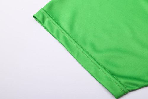 A bright green fabric section of a unisex long-sleeve V-neck shirt with a smooth finish and a branded logo.