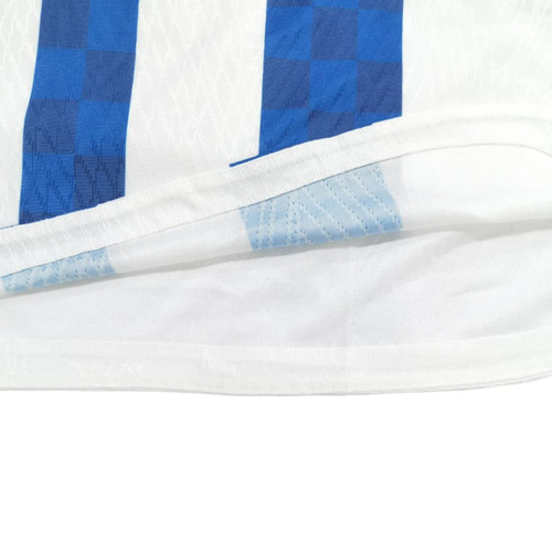 A breathable white T-shirt featuring blue checkered stripes, with a set-in shoulder design, and a logo present.