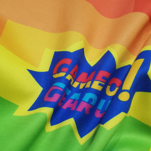 A vibrant, multicoloured fabric featuring a logo in bold lettering, incorporating shades of red, yellow, green, and blue.