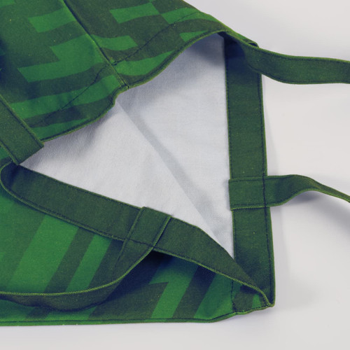 A green 220gsm sublimation canvas tote bag with a patterned exterior and plain interior, featuring sturdy handles.