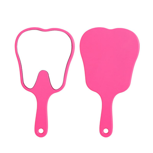 A pink tooth-shaped face mirror with a handle, featuring a reflective surface on one side and a solid backing on the other.