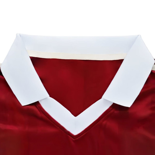 A red sports jersey with a white collar and a V-neck design, featuring a logo. 