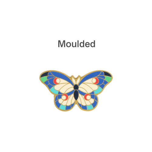 A moulded metal clip featuring a vibrant butterfly design with blue, green, red, and cream colours.