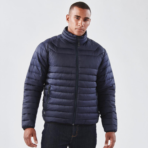 A navy puffer jacket features a high collar and zippered front, worn by a model against a plain background.