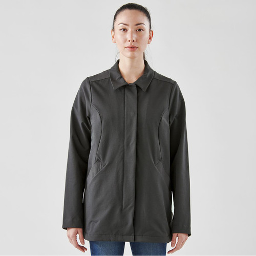 A woman wears a dark grey, long-sleeved Soho jacket with a collar and pockets, featuring a logo.