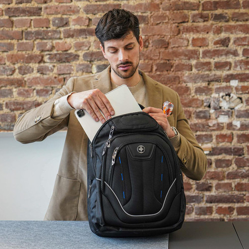 A black Swissdigital Terabyte backpack with blue accents, being opened to store a tablet.
