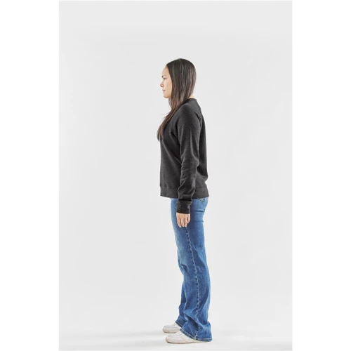 A side view of a woman wearing a black fleece crew neck jumper paired with blue jeans.