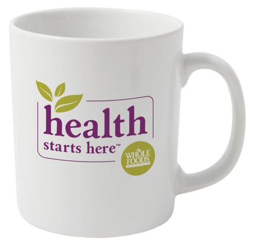 A plain white ceramic mug with a logo and text featuring green leaves and purple lettering.