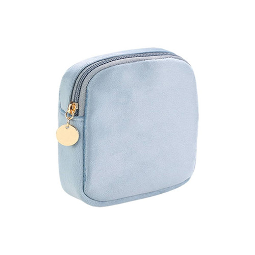 A stylish mini makeup bag in soft blue fabric with a zip closure and gold-tone zipper pull. Features a simple design.