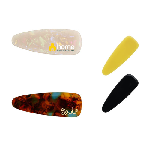 Four acetate hair alligator clips in various colours: clear with a pattern, yellow, black, and tortoiseshell. Each clip features a logo.
