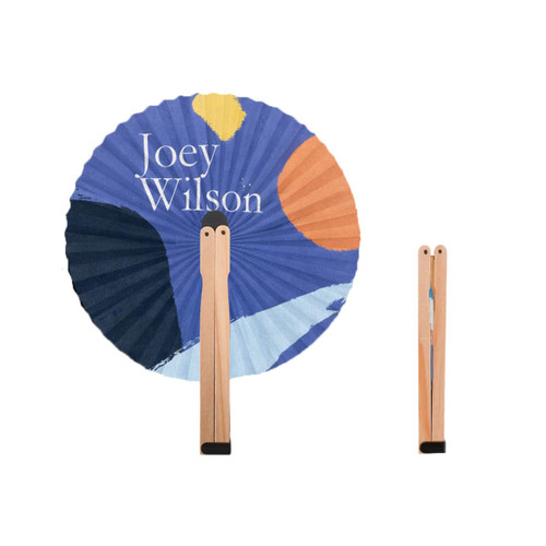 A round wooden paper fan featuring a colourful abstract design with a wooden handle. It has a logo on the handle.