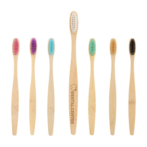 A large bamboo toothbrush with a wooden handle and various coloured nylon bristles, including white, purple, turquoise, and black.