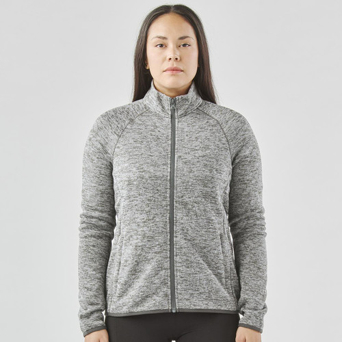 A women's full zip fleece jacket in grey with a high collar and long sleeves, featuring a logo.