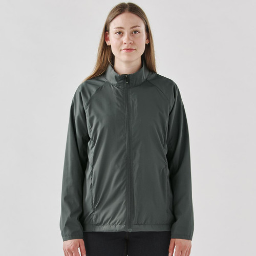 A woman wearing a dark grey full zip rain jacket with a stand collar and a logo on the chest.