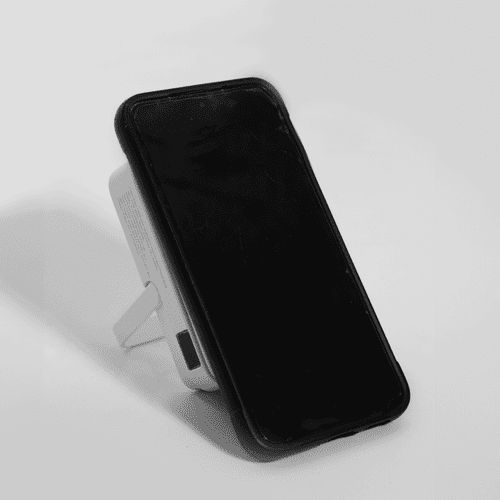 A wireless charging power bank in white, featuring a stand and a black face. It has a logo on the side.