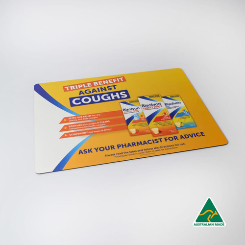 A colourful counter mat featuring a promotional design with products and a logo, highlighting benefits against coughs.