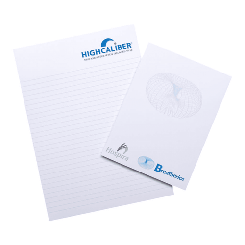 A notepad featuring lined pages, with a logo on the top and a smaller pad beside it, on a wooden surface.