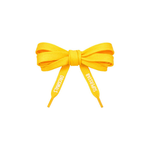 A pair of bright yellow custom shoe laces tied in a bow, featuring a logo on the ends.