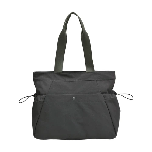 A lightweight grey tote bag featuring yoga mat straps and two exterior pockets, with sturdy handles and a logo.