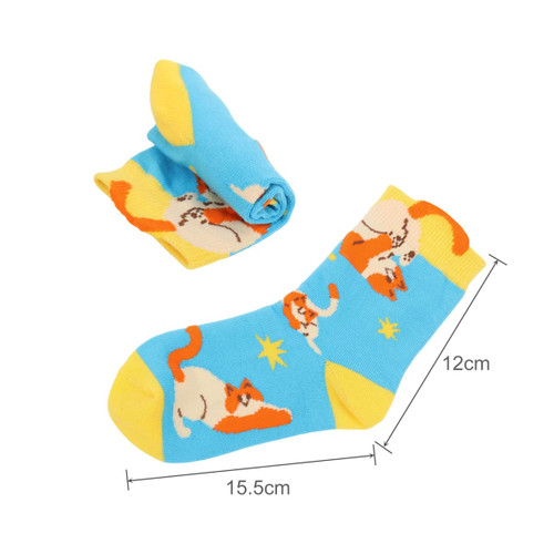 Colourful socks featuring a playful cat design in blue and yellow, with one sock rolled up beside the other.